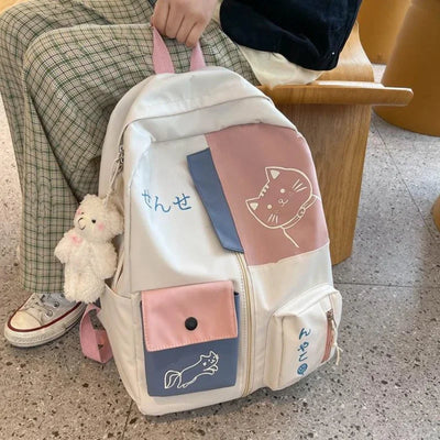 Kawaii cartoon cat backpack with pastel patchwork, bear keychain, and waterproof nylon material for school or travel