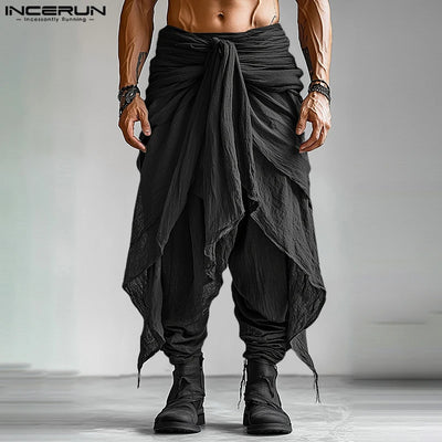 Man wearing black pleated harem pants with layered drape design