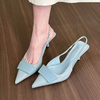 Light blue patent leather women’s slingback pumps with pointed toe, mid heel, and wide front strap – elegant summer party shoes
